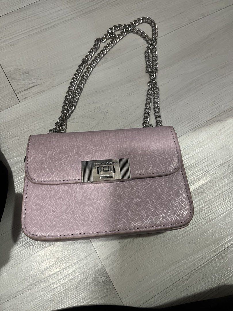 Charles & Keith Pink Shoulder Bag with Chain Strap (Category: Shoulder Bags) located in Pasig City. Submitted by melaiski28 (Listing ID 1462123747, Image 2). Description: - Cute pink shoulder bag by Charles & Keith - Features a stylish silver chain strap - Interior includes a zip pocket and card slots - Secure clasp closure at the front - Perfect for everyday use or going out - Shows minor signs of wear on the inside.
