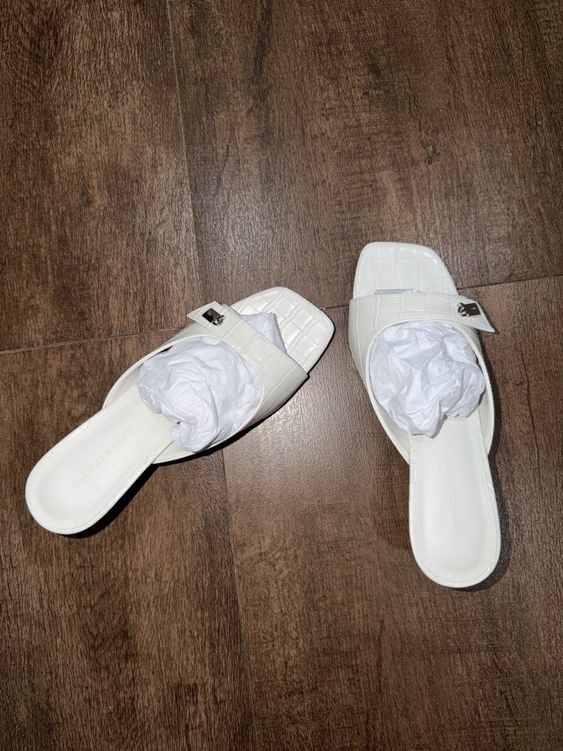 Charles & Keith White Croc Embossed Square Toe Mules Heels Size 36 (Category: Heels) located in Antipolo. Submitted by sugarpop.mnl (Listing ID 1462200341, Image 3). Description: - Brand: Charles & Keith - Color: White - Style: Mules - Size: 36 - Texture: Croc embossed - Design: Square toe with small silver buckle detail - Heel: Low heel, comfortable for walking - Condition: Comes with original box.