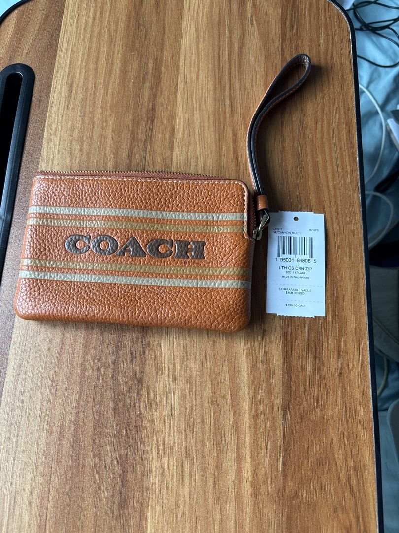 Coach LTH CS CRN ZIP Wristlet Pouch - Orange (Category: Purses & Pouches) located in Manila. Submitted by pugo_08_08_08 (Listing ID 1462045370, Image 1). Description: - Authentic Coach wristlet pouch - Vibrant orange pebbled leather - Stylish horizontal stripe design - Signature Coach logo on front - Secure zipper closure - Convenient wrist strap - Interior card slots for organization - Brand new with original tag attached - Proudly made in the P