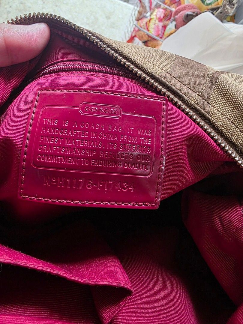 Coach Monogram Canvas Hobo Bag with Red Stripe (Category: Shoulder Bags) located in Lemery. Submitted by venus23 (Listing ID 1462107283, Image 3). Description: - Classic Coach hobo bag -Cherry charm not included - Signature monogram canvas with bold red stripe detail - Vibrant magenta interior - Secure zipper closure - Spacious main compartment - Detachable charm included.