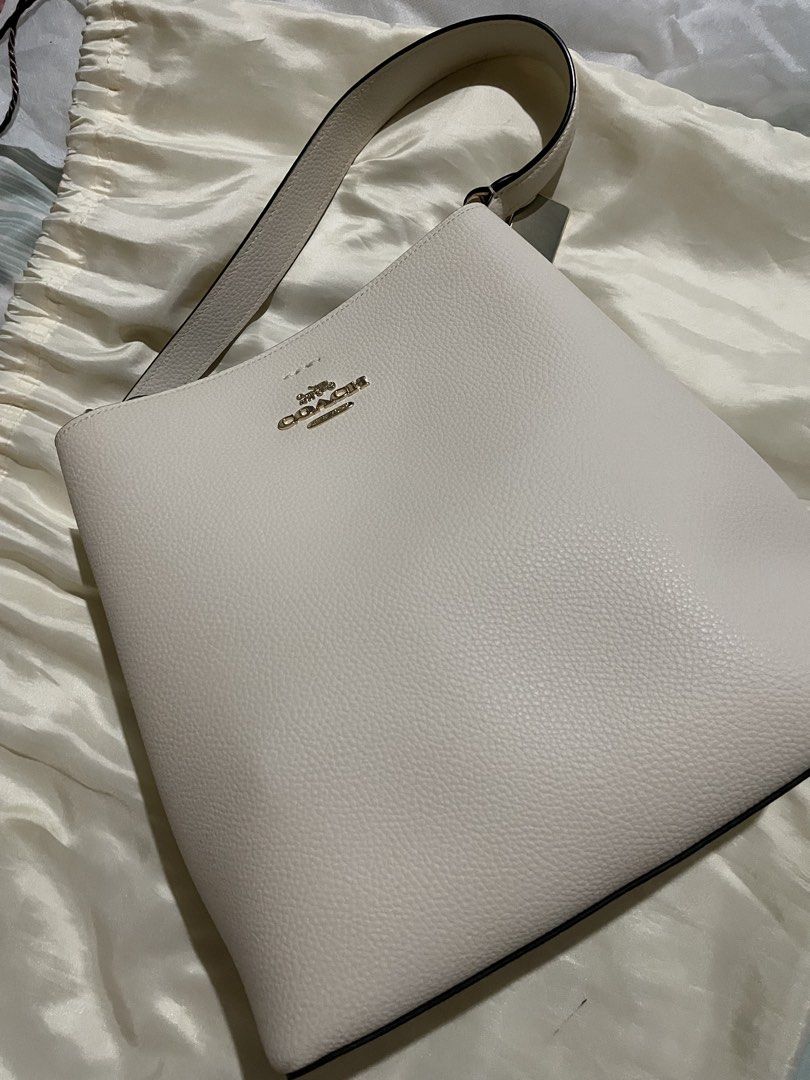 White Coach Pebble Leather Shoulder Bag (Category: Luxury Bags & Wallets) located in Manila. Submitted by real17 (Listing ID 1462117392, Image 2). Description: - Coach white pebble leather shoulder bag - Classic and simple design - Gold hardware details - Spacious interior - Comes with original dust bag - Ideal for everyday use Excellent brand new condition. super nice in actual PAYMENT FIRST BEFORE BOOKING. DONT BUY IF IN DOUBT. THIS IS AUTHENTI