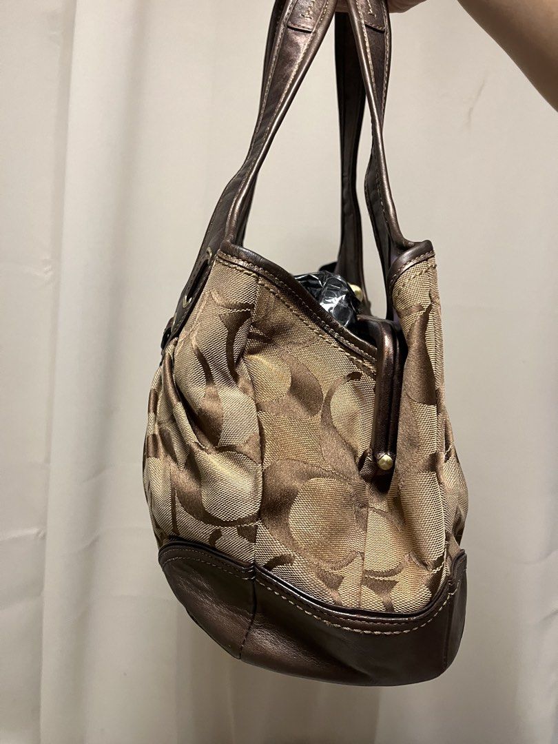 sold (Category: Luxury Bags & Wallets) located in Cabanatuan. Submitted by designerdepot.c (Listing ID 1462164874, Image 3). Description: - Coach hobo bag in signature C monogram print - Color: Brown and tan canvas with metallic bronze leather trim - Features a drawstring detail with a small bow and charm - Top handle for comfortable carrying - Interior zip pocket for essentials - Ideal everyday bag -discoloration issues -faded issues.