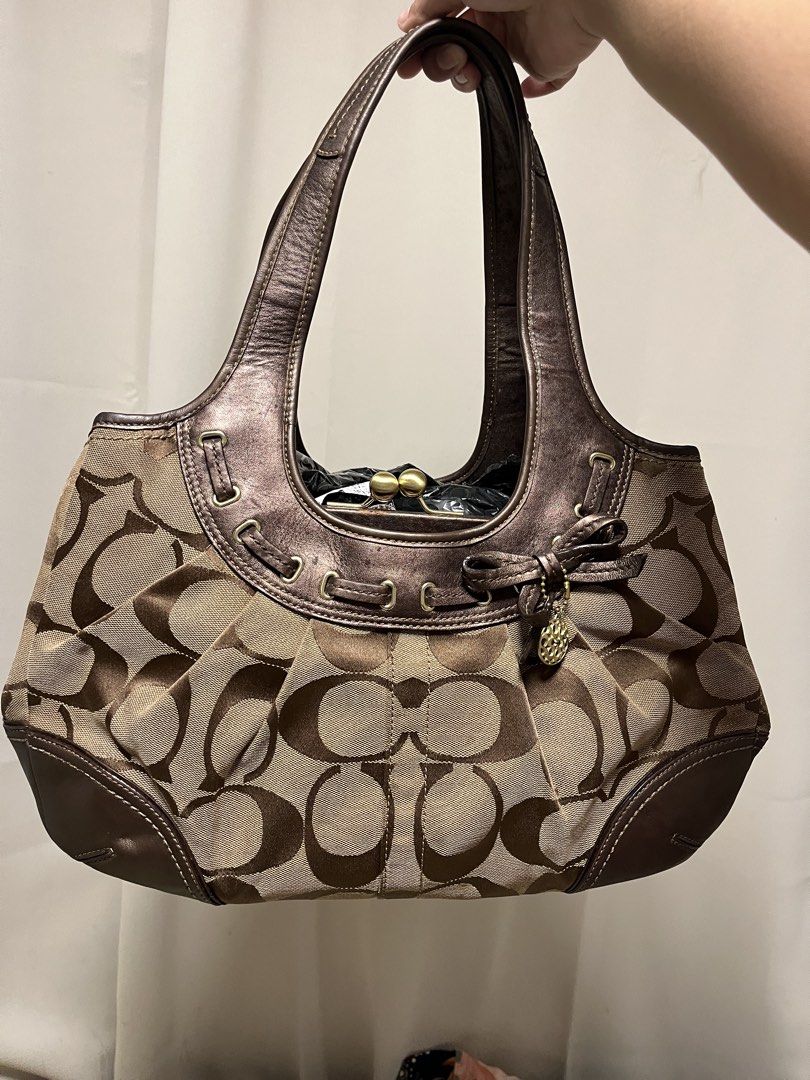 sold (Category: Luxury Bags & Wallets) located in Cabanatuan. Submitted by designerdepot.c (Listing ID 1462164874, Image 1). Description: - Coach hobo bag in signature C monogram print - Color: Brown and tan canvas with metallic bronze leather trim - Features a drawstring detail with a small bow and charm - Top handle for comfortable carrying - Interior zip pocket for essentials - Ideal everyday bag -discoloration issues -faded issues.