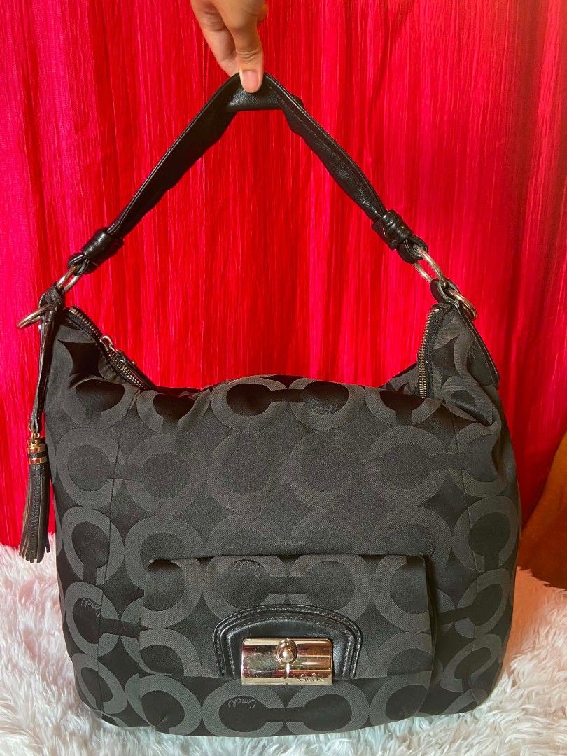 Coach Signature Monogram Hobo Bag (Category: Luxury Bags & Wallets) located in Bulacan. Submitted by bella.ken.varietystore (Listing ID 1462179813, Image 1). Description: - Authentic Black Coach Hobo Bag - Signature 'C' Monogram Pattern - Genuine Leather Straps and Trim - Front Flap Pocket with Turn-Lock Closure - Decorative Side Tassels - Spacious Interior - Ideal for Everyday Essentials - Versatile and Stylish for Daily Wear.