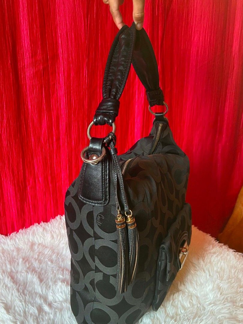 Coach Signature Monogram Hobo Bag (Category: Luxury Bags & Wallets) located in Bulacan. Submitted by bella.ken.varietystore (Listing ID 1462179813, Image 2). Description: - Authentic Black Coach Hobo Bag - Signature 'C' Monogram Pattern - Genuine Leather Straps and Trim - Front Flap Pocket with Turn-Lock Closure - Decorative Side Tassels - Spacious Interior - Ideal for Everyday Essentials - Versatile and Stylish for Daily Wear.