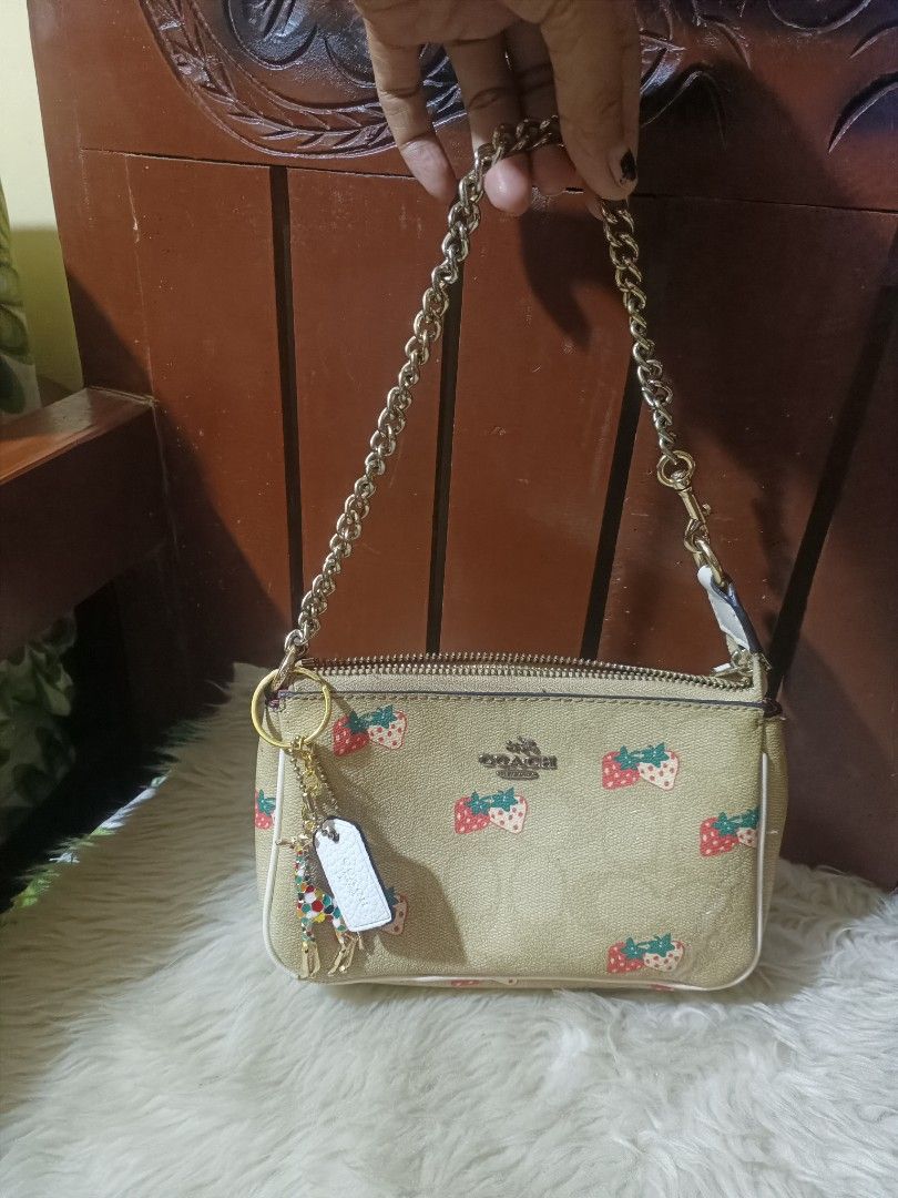 Coach Strawberry Print Wristlet Pouch (Category: Purses & Pouches) located in Cebu City. Submitted by elen30abalo (Listing ID 1462044988, Image 1). Description: Cute Coach wristlet with a fun strawberry print. Tan background with red and green strawberries. Comes with a gold chain strap and a cute giraffe charm. Zipper closure. Great for essentials..
