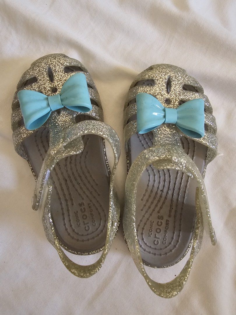 Crocs Glitter Jelly Sandals with Bows (Category: Flats & Sandals) located in Cebu City. Submitted by cutexoxoshop (Listing ID 1462189502, Image 1). Description: - Sparkly silver glitter jelly sandals by Crocs - Adorable light blue bows on the front - Easy slip-on style for kids - Soles with good grip for safety - Comfortable and fun for summer or dress-up play.