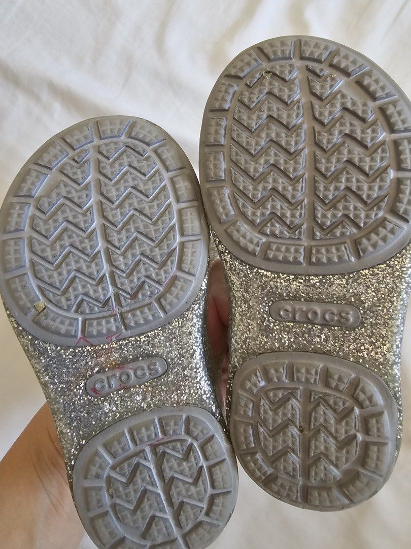 Crocs Glitter Jelly Sandals with Bows (Category: Flats & Sandals) located in Cebu City. Submitted by cutexoxoshop (Listing ID 1462189502, Image 3). Description: - Sparkly silver glitter jelly sandals by Crocs - Adorable light blue bows on the front - Easy slip-on style for kids - Soles with good grip for safety - Comfortable and fun for summer or dress-up play.