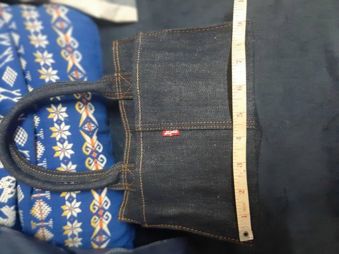 Denim Tote Bag with Red Tab Detail (Category: Tote Bags) located in Bulacan. Submitted by edisoncert71953 (Listing ID 1462053874, Image 3). Description: - Dark wash denim tote bag - Simple and sturdy construction - Small red tab detail on the side - Braided denim handles - Ideal for everyday use - Dimensions: Approx. 6 inches tall, 4 inches wide.