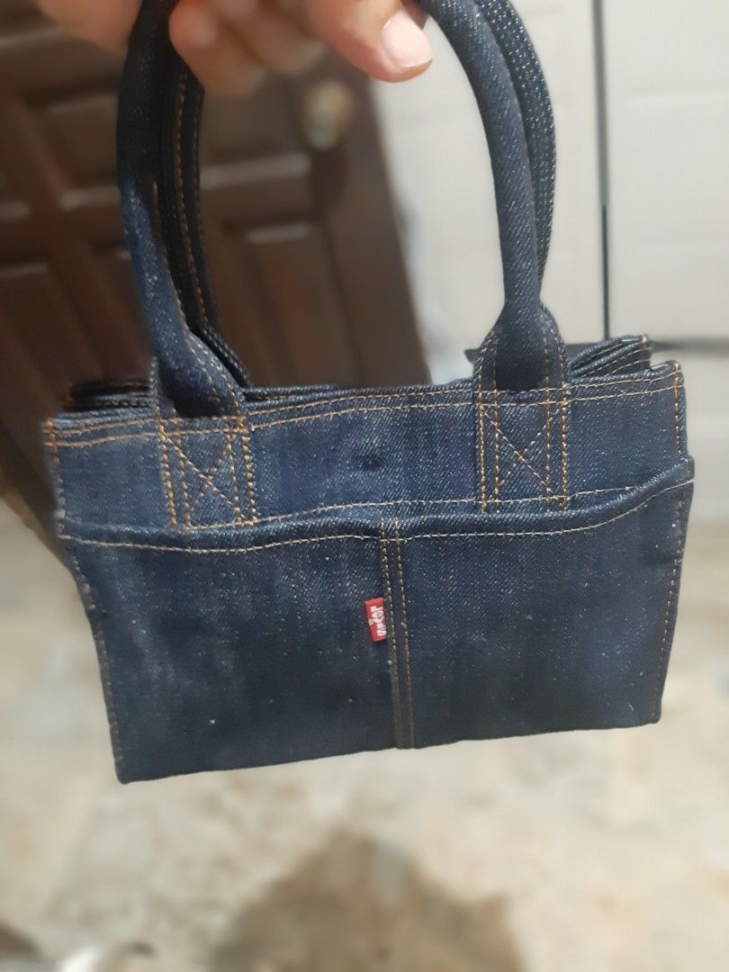 Denim Tote Bag with Red Tab Detail (Category: Tote Bags) located in Bulacan. Submitted by edisoncert71953 (Listing ID 1462053874, Image 1). Description: - Dark wash denim tote bag - Simple and sturdy construction - Small red tab detail on the side - Braided denim handles - Ideal for everyday use - Dimensions: Approx. 6 inches tall, 4 inches wide.