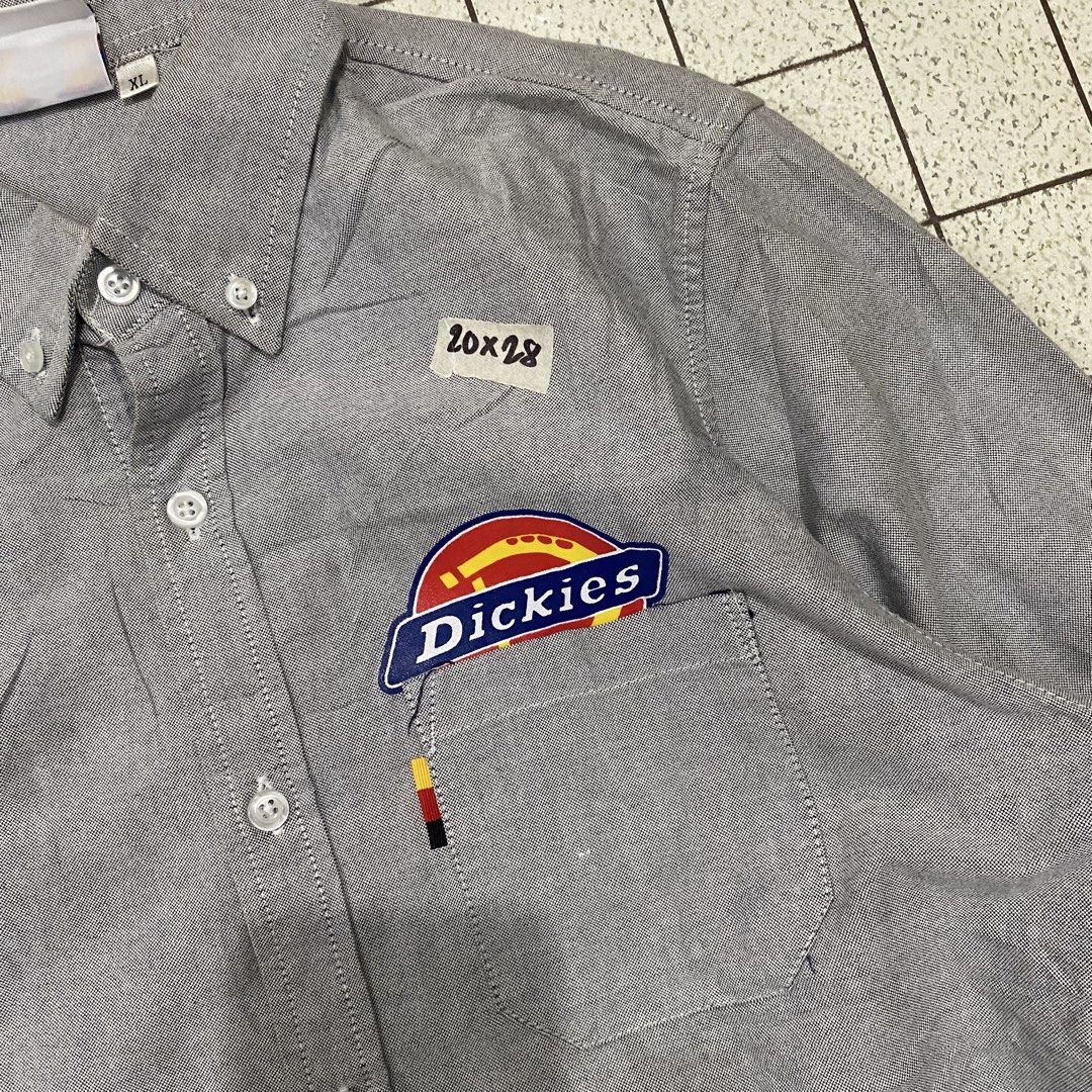 Dickies Oxford Button Down Shirt Grey XL (Category: Tshirts & Polo Shirts ) located in Manila. Submitted by sepamorash53558 (Listing ID 1462080599, Image 3). Description: - Grey Dickies button down shirt - Made from Oxford fabric - Features classic Dickies logo patch on chest pocket and sleeve - Small '10x28' detail above pocket - Size XL - Ideal for workwear or casual wear.