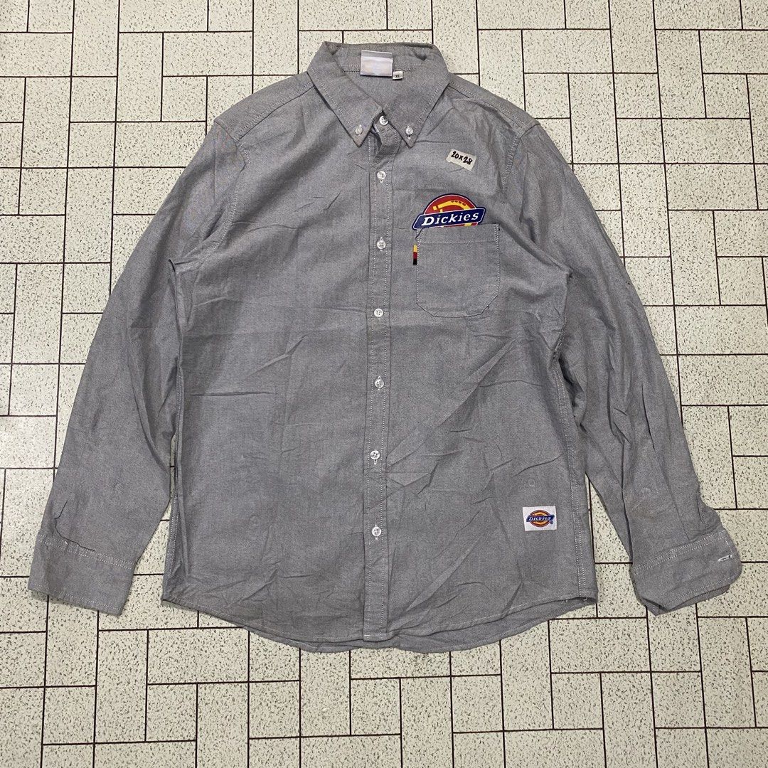Dickies Oxford Button Down Shirt Grey XL (Category: Tshirts & Polo Shirts ) located in Manila. Submitted by sepamorash53558 (Listing ID 1462080599, Image 1). Description: - Grey Dickies button down shirt - Made from Oxford fabric - Features classic Dickies logo patch on chest pocket and sleeve - Small '10x28' detail above pocket - Size XL - Ideal for workwear or casual wear.