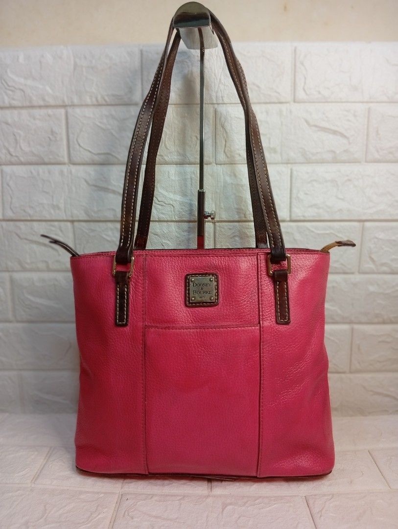 Dooney & Bourke Pink Leather Tote Bag (Category: Tote Bags) located in Las Pinas. Submitted by etoksi1234 (Listing ID 1462216231, Image 1). Description: Pre-loved Dooney & Bourke bright pink Pebble Grain Lexington tote featuring contrasting dark brown leather shoulder straps and a signature metal logo patch. Size: L-12" x H-10" x D-3.5".