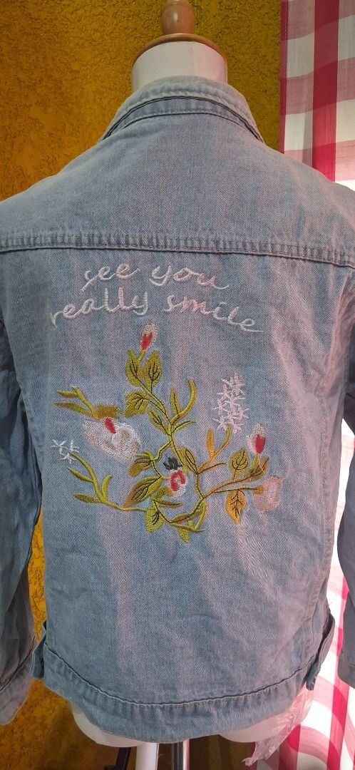 Embroidered Denim Jacket with "See You Really Smile" (Category: Coats, Jackets and Outerwear) located in Manila. Submitted by katkween23 (Listing ID 1462063627, Image 3). Description: - Light wash denim jacket - Beautiful floral embroidery on the back - Features text "see you really smile" - Classic button-up style - Two chest pockets - Ideal for layering - Unique and eye-catching piece.