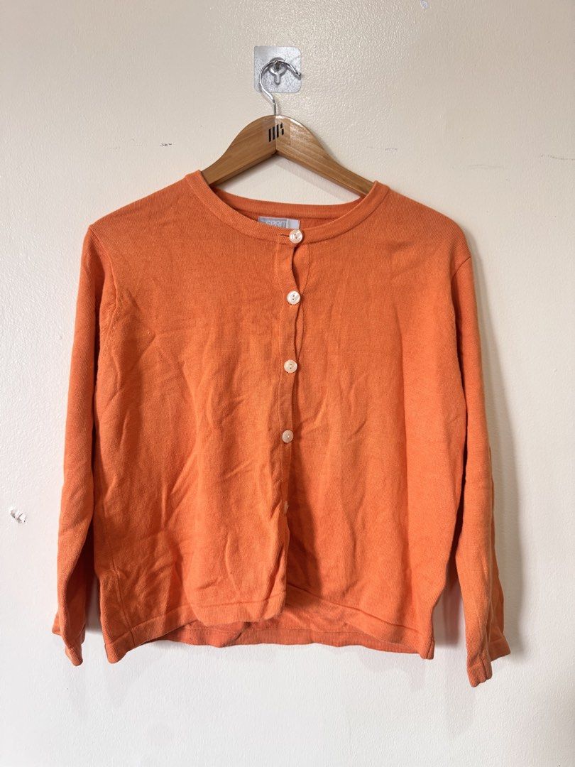 Esprit Orange Button Up Cardigan (Category: Coats, Jackets and Outerwear) located in Paranaque City. Submitted by simplylizzy (Listing ID 1462068532, Image 1). Description: - Orange Esprit cardigan - Lightweight knit fabric - Button-up front closure - Classic round neckline - Ideal for layering over tops or dresses - Simple and timeless design.