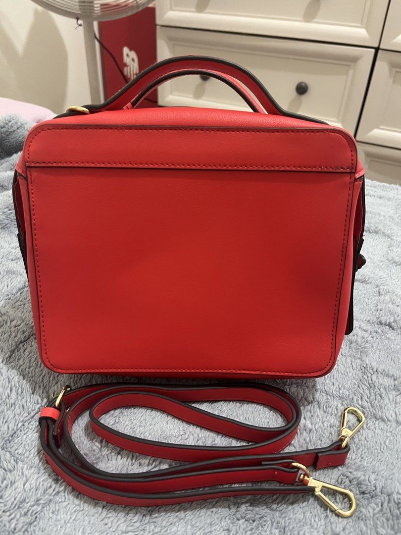 Estee Lauder Red Leather Handbag with Bee Charm (Category: Luxury Bags & Wallets) located in Mandaluyong City. Submitted by leypadilla (Listing ID 1462102363, Image 2). Description: - Genuine red leather handbag from Estee Lauder - Adorable gold bee charm on front tag - Stylish gold bee zipper pull - Includes a detachable crossbody strap for versatile wear - Immaculate and clean interior - Ideal for both daily use and special events.