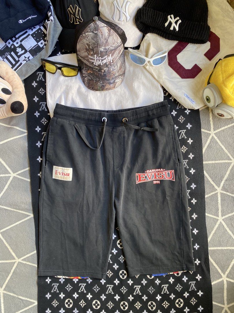 EVISU Daruma 1991 Graphic Shorts (Category: Shorts) located in Manila. Submitted by thriftfindnicarl (Listing ID 1462047792, Image 2). Description: - Black Evisu shorts - Iconic Daruma graphic on the back - Evisu 1991 logo on the front left leg - Comfortable drawstring waist - Ideal for streetwear enthusiasts - COLOR RATE 8/10.