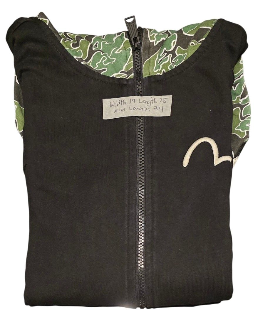 EVISU Zip-Up Hoodie (Category: Hoodies) located in Quezon City. Submitted by ShoesManila (Listing ID 1462208080, Image 3). Description: Width 19 Length 25 Arm length 24 - Black Evisu zip-up hoodie - Iconic Evisu logo on front - "Specials" text graphic on sleeve - Camouflage lining on the hood Ready to ship No COD Location: Diliman, QC .