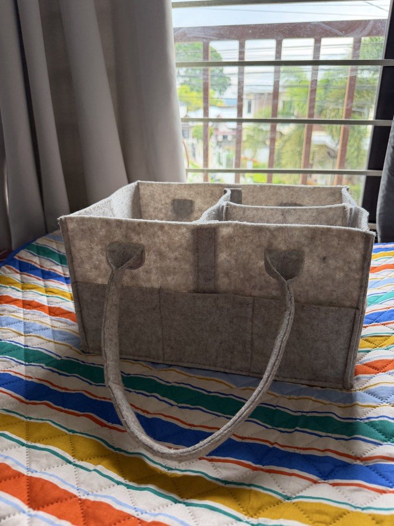 Felt Storage Organizer Bag with Handles and Pockets (Category: Diaper Bags & Wetbags) located in Davao. Submitted by lyscapuno (Listing ID 1462085962, Image 3). Description: - Beige Grey felt storage bag - Multiple interior compartments - Several exterior pockets for extra storage - Sturdy handles for easy carrying - Ideal for organizing baby items, craft supplies, or car essentials - Keeps your space tidy and organized.