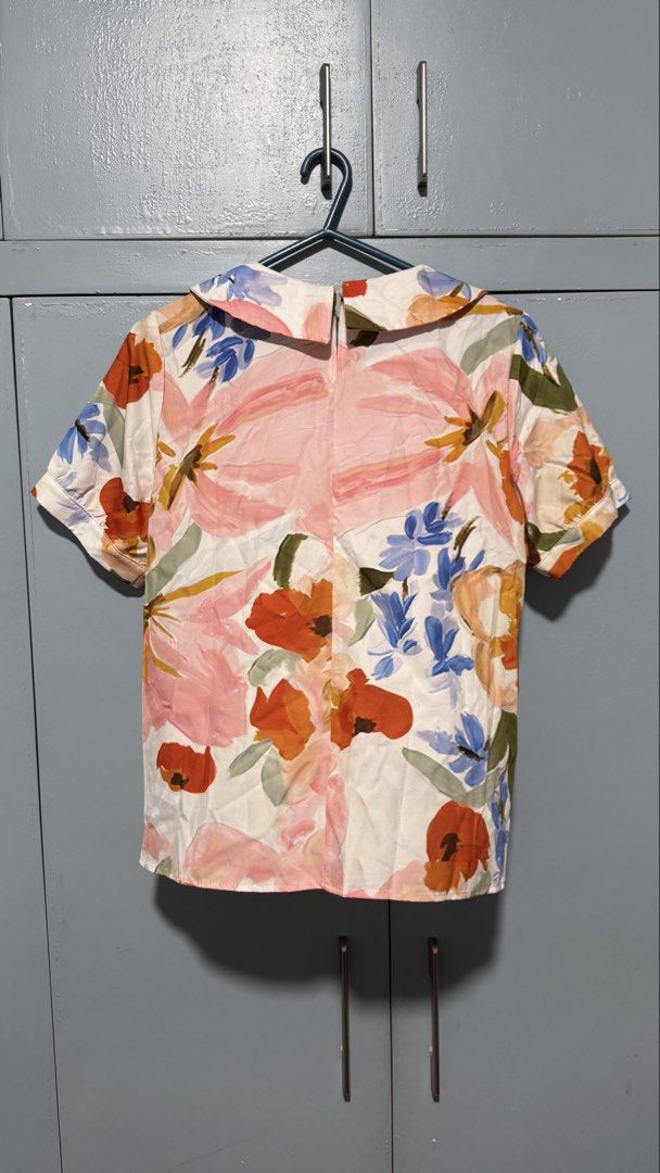 Floral Print Peter Pan Collar Top (Category: Blouses) located in Quezon City. Submitted by amogz (Listing ID 1462086846, Image 2). Description: - White top with vibrant floral print - Features a charming Peter Pan collar - Short sleeves for a comfortable fit - Made from 100% polyester fabric - Perfect for both casual and dressy occasions - Easily pairs with skirts or pants.