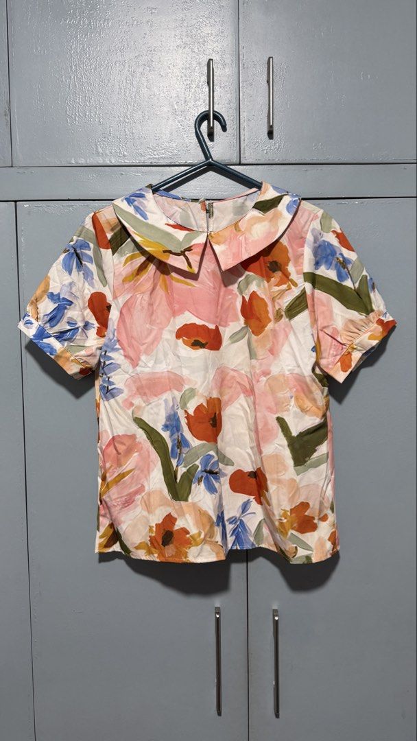 Floral Print Peter Pan Collar Top (Category: Blouses) located in Quezon City. Submitted by amogz (Listing ID 1462086846, Image 1). Description: - White top with vibrant floral print - Features a charming Peter Pan collar - Short sleeves for a comfortable fit - Made from 100% polyester fabric - Perfect for both casual and dressy occasions - Easily pairs with skirts or pants.
