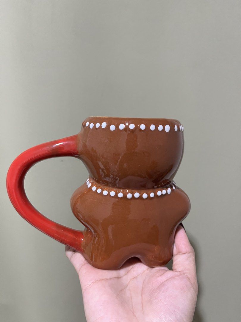 Gingerbread Man Mug with Red Handle ceramic (Category: Coffee & Tea Tableware) located in Manila. Submitted by vaughnscloset (Listing ID 1462070925, Image 2). Description: - Adorable gingerbread man design - White icing details and red bow tie/button accents - Sturdy red handle - Ideal for morning coffee or hot chocolate - Festive and unique, perfect for the holiday season - With hairline, for display only..