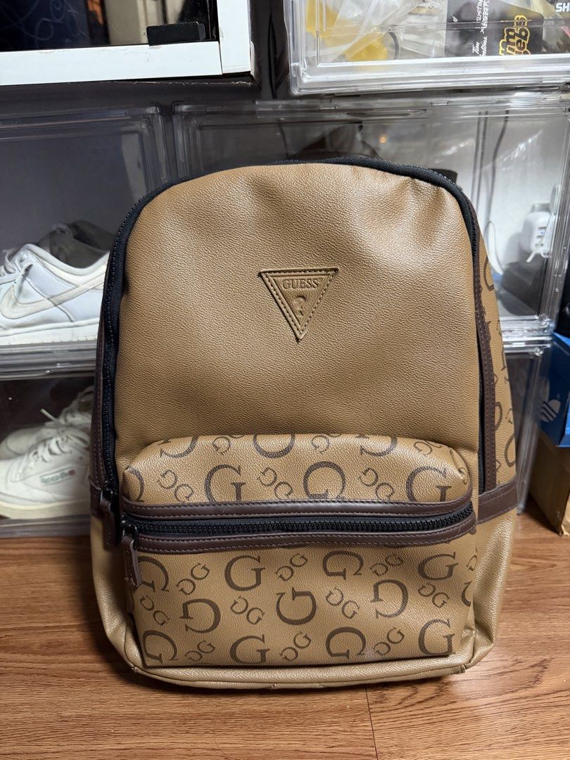 Guess Insignia Monogram Backpack Brown (Category: Backpacks) located in Cainta. Submitted by tinpalma (Listing ID 1462090631, Image 1). Description: - Stylish brown Guess backpack with all-over monogram print. - Features a convenient front zip pocket. - Main compartment includes internal pockets for organization. - Padded back and adjustable straps ensure maximum comfort. - Ideal for everyday use, school, or travel adventures..