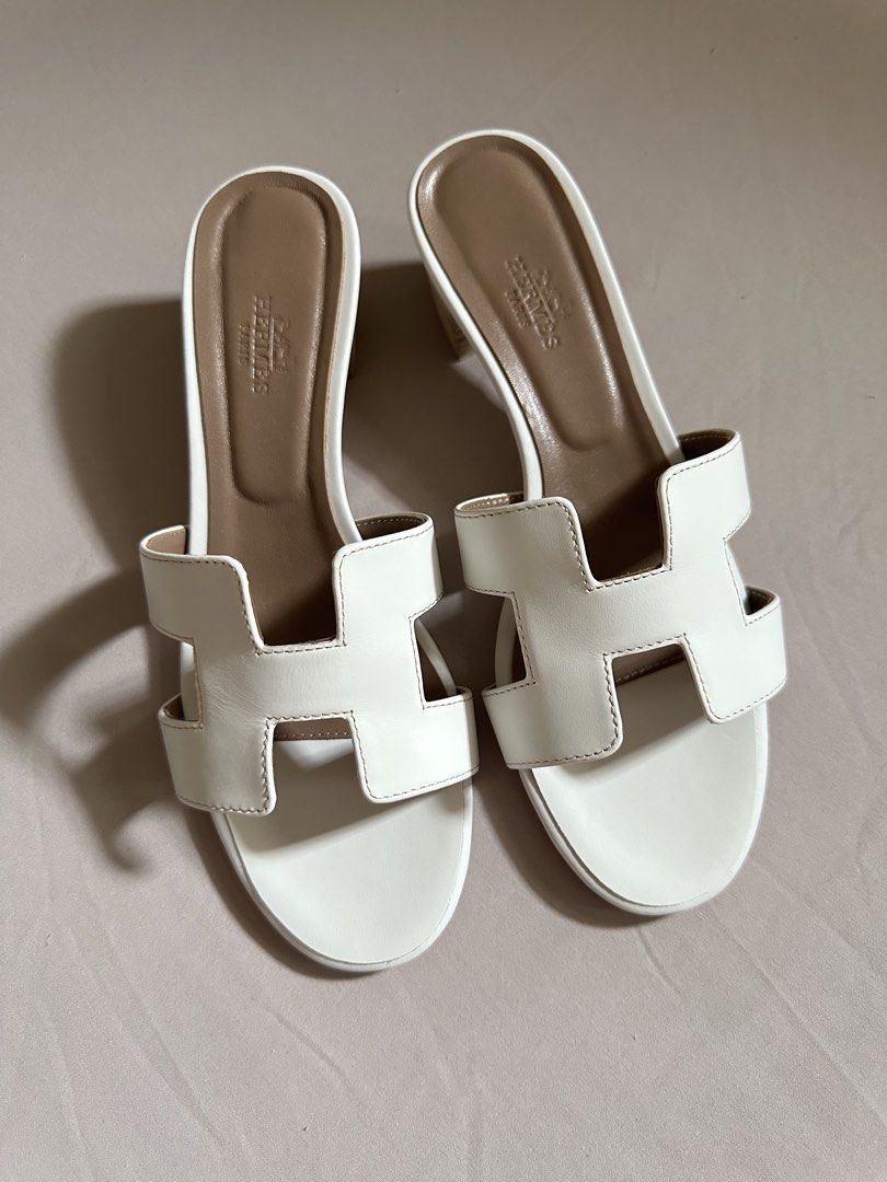 Hermes sandals (Category: Flats & Sandals) located in Legazpi City. Submitted by gettinmycloset01 (Listing ID 1462121752, Image 1). Description: - Authentic white leather Hermes oasis sandals - Features the iconic 'H' design - Comfortable block heel for all-day wear - Classic and chic style - Perfect for dressing up or down - A versatile addition to your wardrobe.