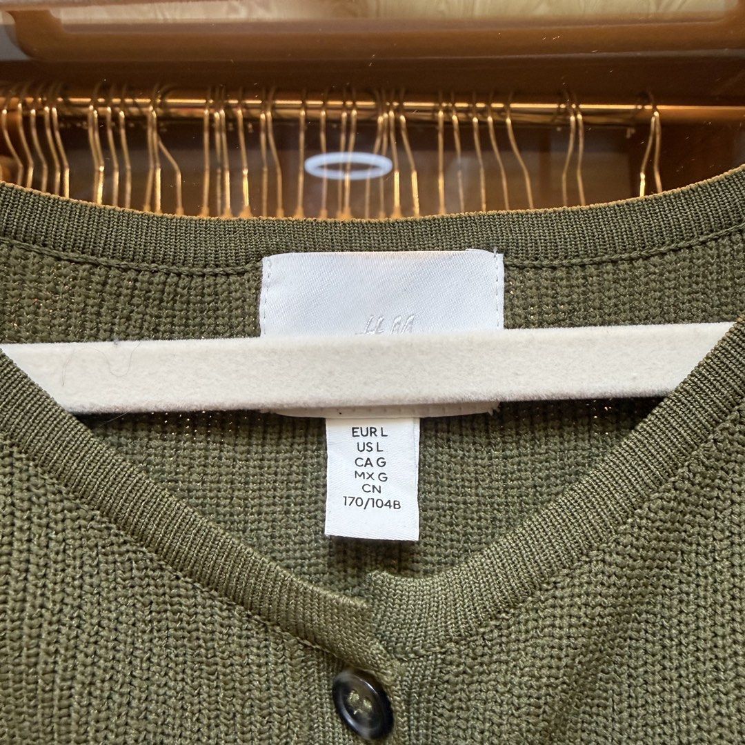 H&M Sleeveless Knit Button-Up Top - Olive Green (Category: Sleeveless) located in Manila. Submitted by khazie. (Listing ID 1462226533, Image 2). Description: - H&M Olive Green Sleeveless Knit Top - Size: Large (L) - Features: Button-up front, flared hem - Material: Textured knit - Style: Versatile for layering or standalone wear.