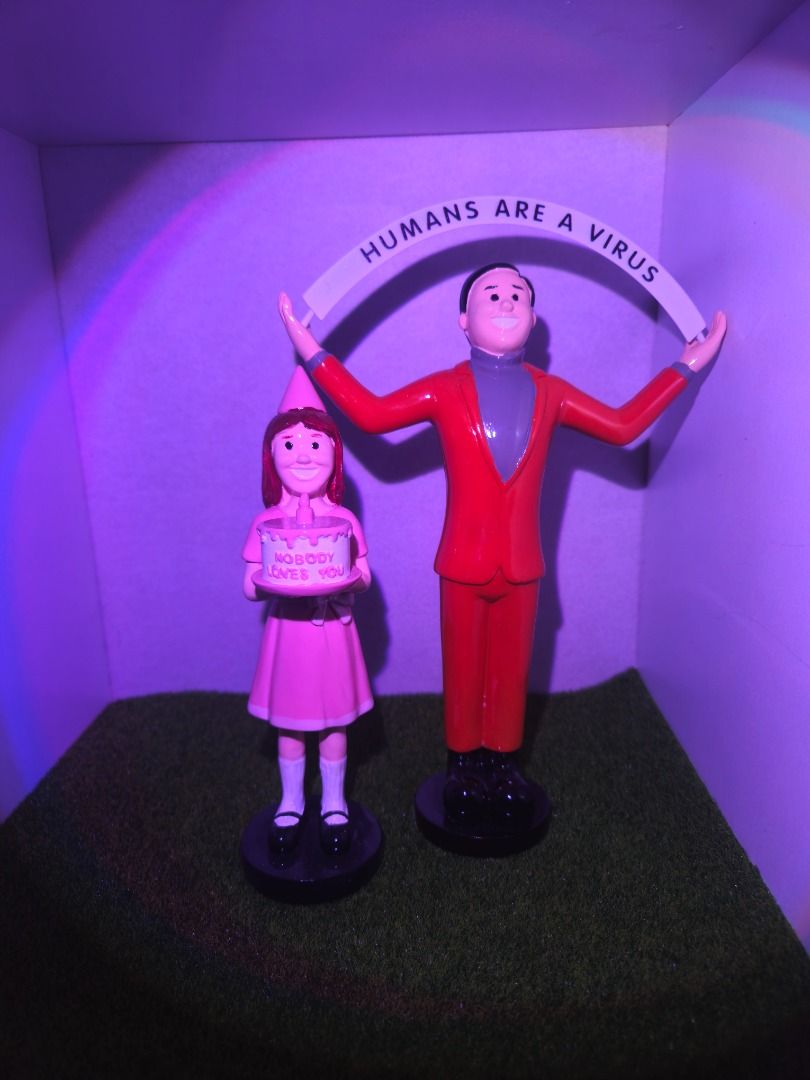 Joan Cornelia Figurine set (Memes) (Category: Figurines & Statues) located in Binan City. Submitted by davyltnh (Listing ID 1462257887, Image 1). Description: Joan Cornelia set Size: 11" and 8" Price: Php: 1k - Set of 2 quirky figurines - Figurine 1: Girl with birthday cake that says 'Nobody Loves You' - Figurine 2: Man holding a sign that reads 'Humans Are A Virus' - Ideal for gag gifts or unique desk decor - Both figurines stand on black bases 