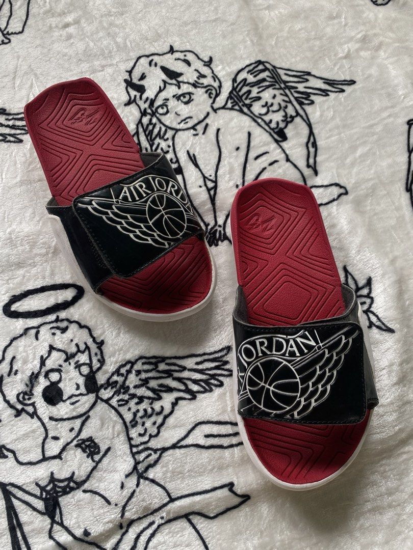 Jordan Air Slides Black Red Size (Category: Slippers & Slides) located in Cagwait. Submitted by roundsociety_ph (Listing ID 1462223847, Image 3). Description: - Authentic Jordan Air Slides - Classic Black and Red colorway - Prominent Jordan logo on strap - Red sole with grip pattern for traction - Size: 4Y (US Youth) / 36 (EUR) / 23 CM - Ideal for everyday casual wear or post-game relaxation - Made in China.