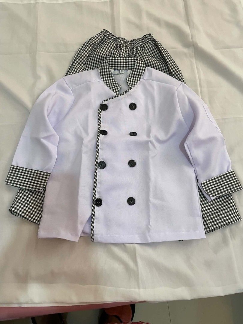 Kids Chef Uniform Set - White Jacket and Gingham Pants (Category: Babies & Kids Fashion) located in Makati City. Submitted by primadonna00 (Listing ID 1462261434, Image 1). Description: - Adorable chef uniform for kids - White double-breasted jacket with black buttons and gingham trim - Matching gingham pants with elastic waistband - Ideal for dress-up and imaginative play - Estimated size for children aged 5-7 years (check measurements for best 