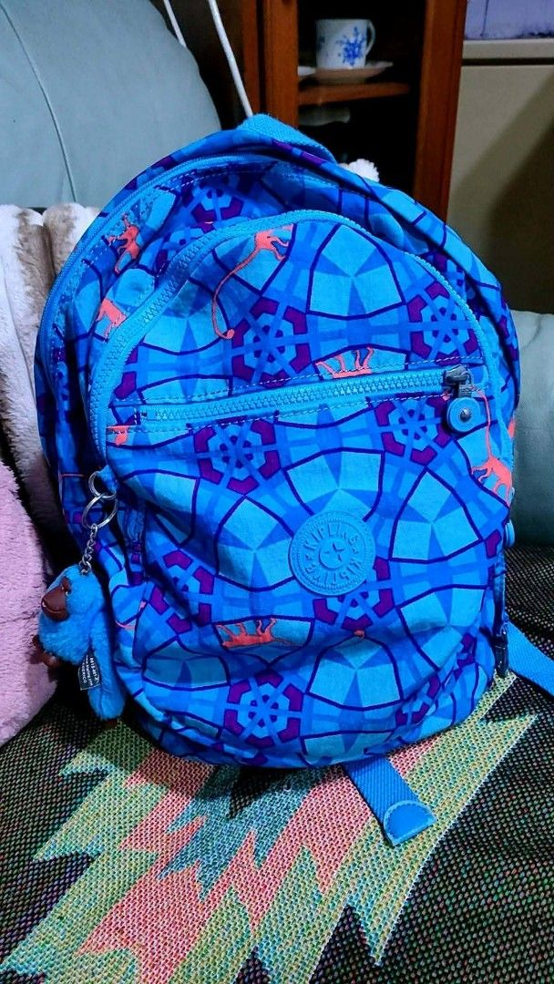 Kipling Backpack - Blue Geometric Pattern with Monkey Charm (Category: Backpacks) located in Baliuag. Submitted by marieannfernando23 (Listing ID 1462143268, Image 1). Description: - Medium 16 x 11" - Adorable Kipling backpack - Fun blue geometric pattern with orange dinosaur figures - Comes with the signature Kipling monkey charm - Zippers are in excellent working condition - Spacious interior, perfect for school or everyday essentials - Versati