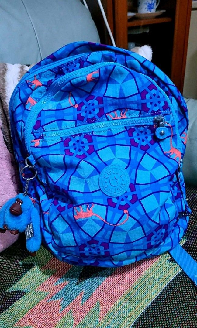 Kipling Backpack - Blue Geometric Pattern with Monkey Charm (Category: Backpacks) located in Baliuag. Submitted by marieannfernando23 (Listing ID 1462143268, Image 2). Description: - Medium 16 x 11" - Adorable Kipling backpack - Fun blue geometric pattern with orange dinosaur figures - Comes with the signature Kipling monkey charm - Zippers are in excellent working condition - Spacious interior, perfect for school or everyday essentials - Versati