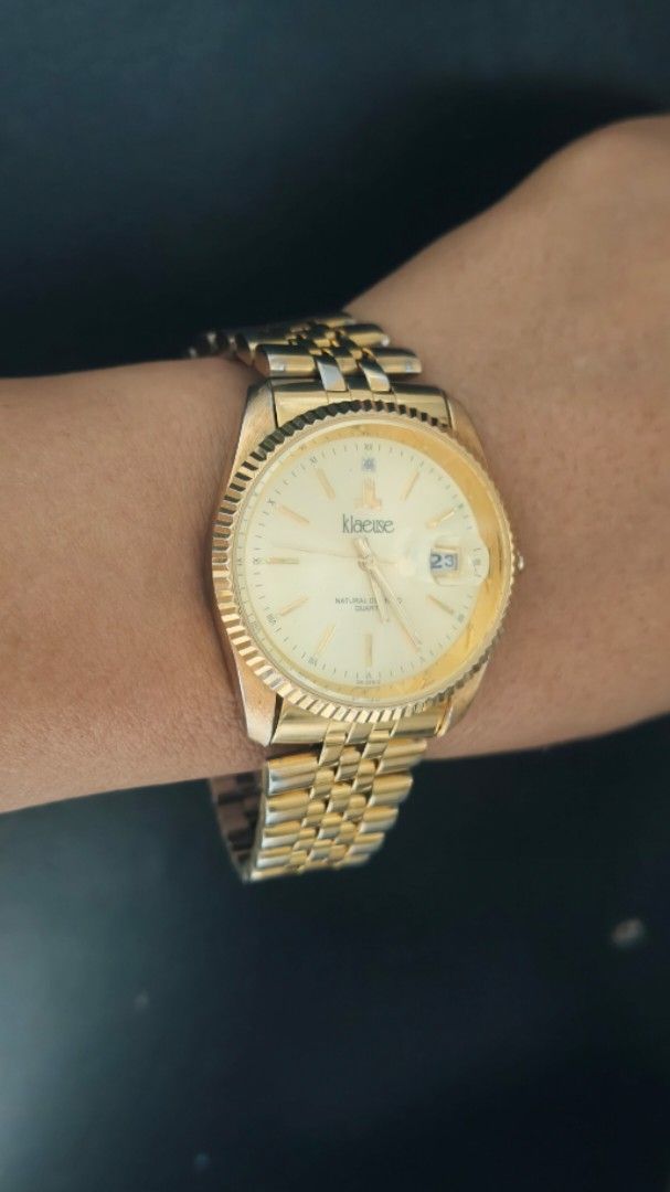 Klaese Gold Tone Watch with Date Window (Category: Women's Watches) located in Taguig. Submitted by mercyeugen28914 (Listing ID 1462132031, Image 2). Description: - Gold tone watch from Klaese - Classic design with fluted bezel - Date window at 3 o'clock - Two-tone gold and silver bracelet - In good working condition.