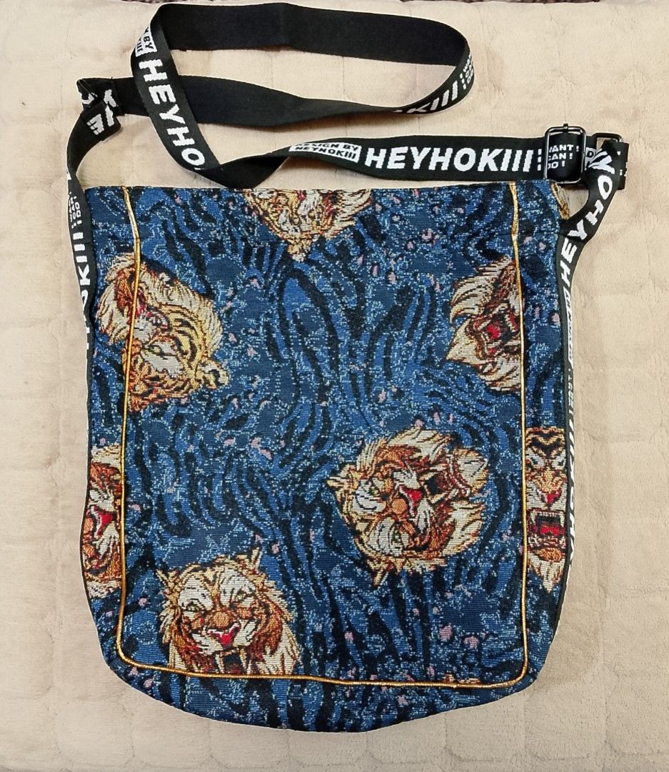 Large tote or hobo style shoulder bag (Category: Tote Bags) located in Caloocan City. Submitted by pvaliao (Listing ID 1462065799, Image 3). Description: Brand: HEYHOKIII Pre owned Price: 150 Size: 13 inches × 14 inches This large tote or hobo - style shoulder bag features a distinctive, streetwear - inspired aesthetic tapestry - like pattern with a dark blue and grey swirling like backdrop. The pattern consists of detailed, roaring tiger faces r