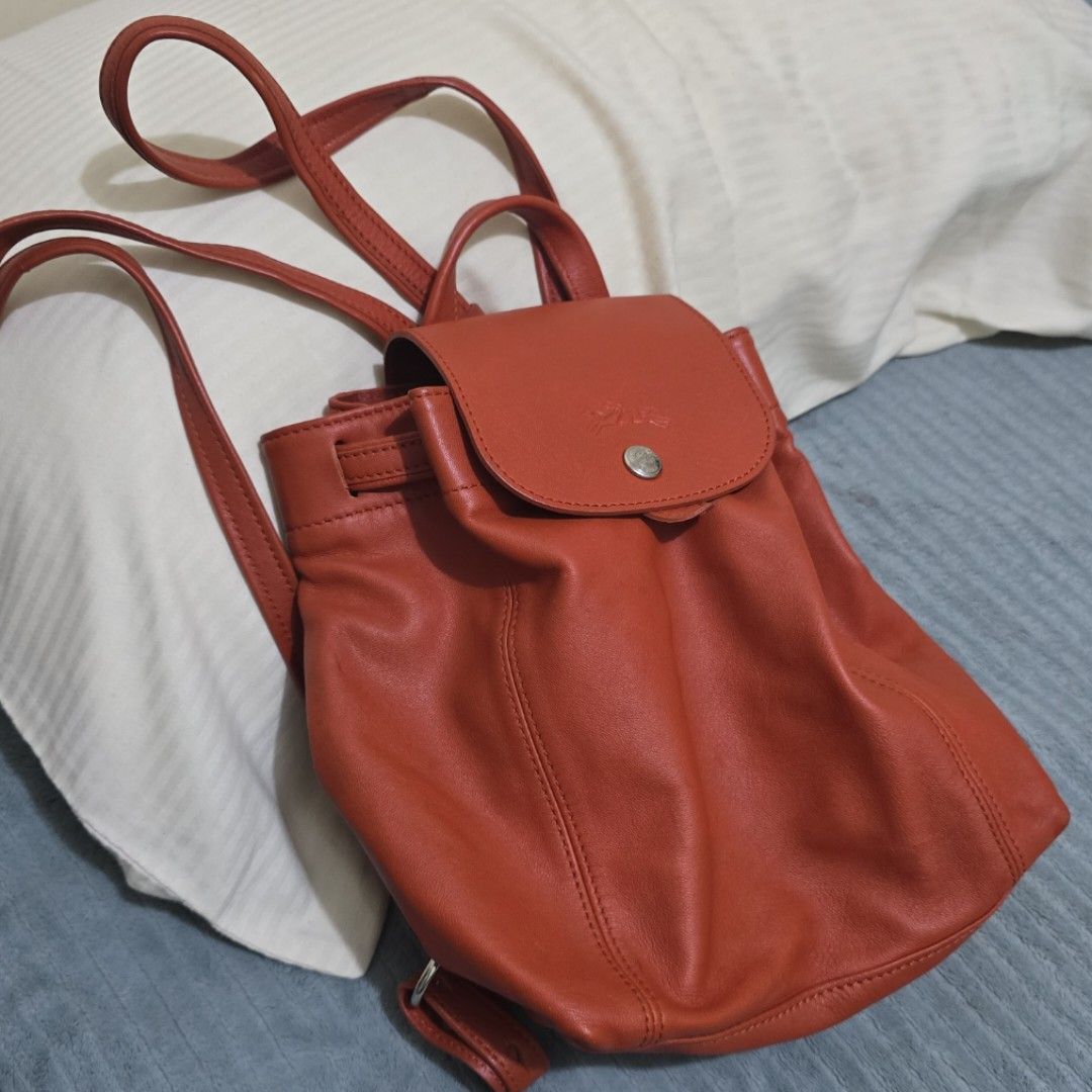 Longchamp Le Pliage Cuir Backpack Orange Leather (Category: Backpacks) located in Pasig City. Submitted by litinpink (Listing ID 1462053676, Image 1). Description: - Authentic Orange Longchamp Leather Backpack - Signature embossed horse and rider logo on flap - Secure drawstring closure with snap button flap - Interior zippered pocket for essentials - Playful horse print lining - Adjustable straps for comfortable wear.