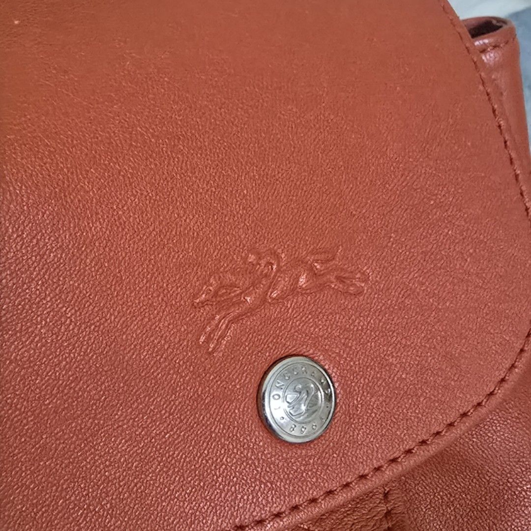 Longchamp Le Pliage Cuir Backpack Orange Leather (Category: Backpacks) located in Pasig City. Submitted by litinpink (Listing ID 1462053676, Image 2). Description: - Authentic Orange Longchamp Leather Backpack - Signature embossed horse and rider logo on flap - Secure drawstring closure with snap button flap - Interior zippered pocket for essentials - Playful horse print lining - Adjustable straps for comfortable wear.