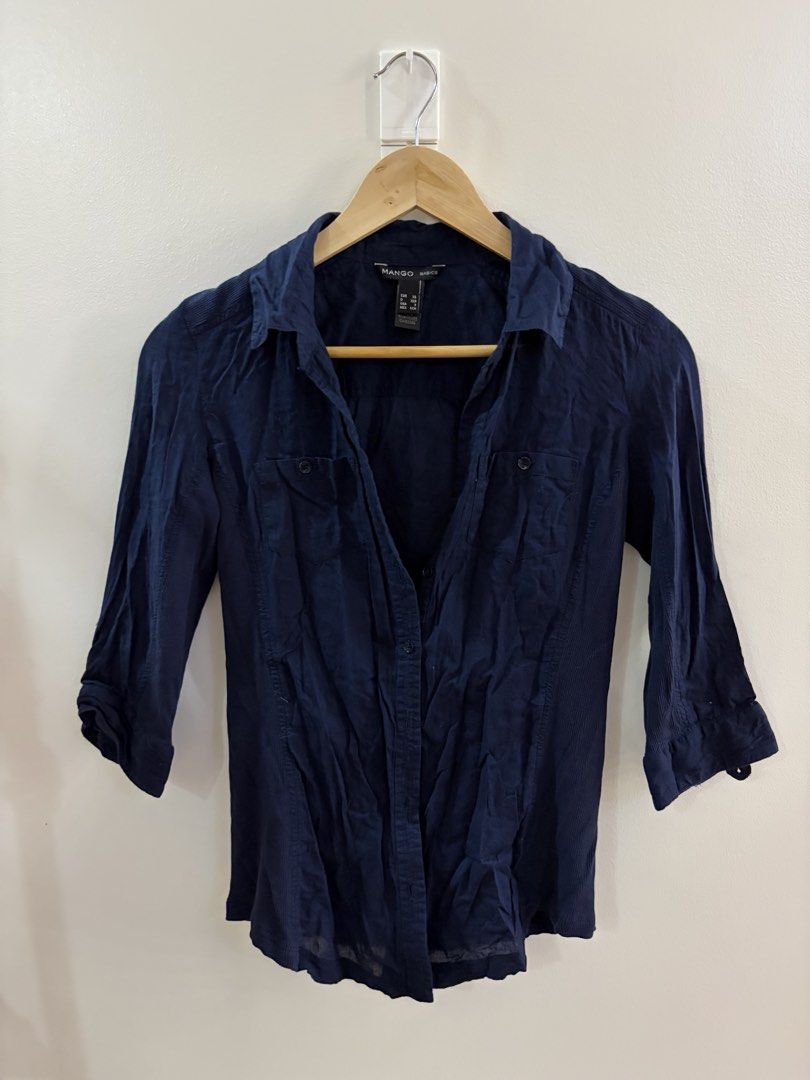 Mango Basics Navy Blue Button-Up Shirt 3/4 Sleeves (Category: Longsleeves) located in San Juan City. Submitted by sel.ler (Listing ID 1462126998, Image 1). Description: - Brand: Mango Basics - Color: Navy Blue - Sleeve Length: Three-quarter sleeves with button tabs for roll-up option - Pockets: Two chest pockets - Closure: Button-up front - Fabric: Lightweight, ideal for casual wear.