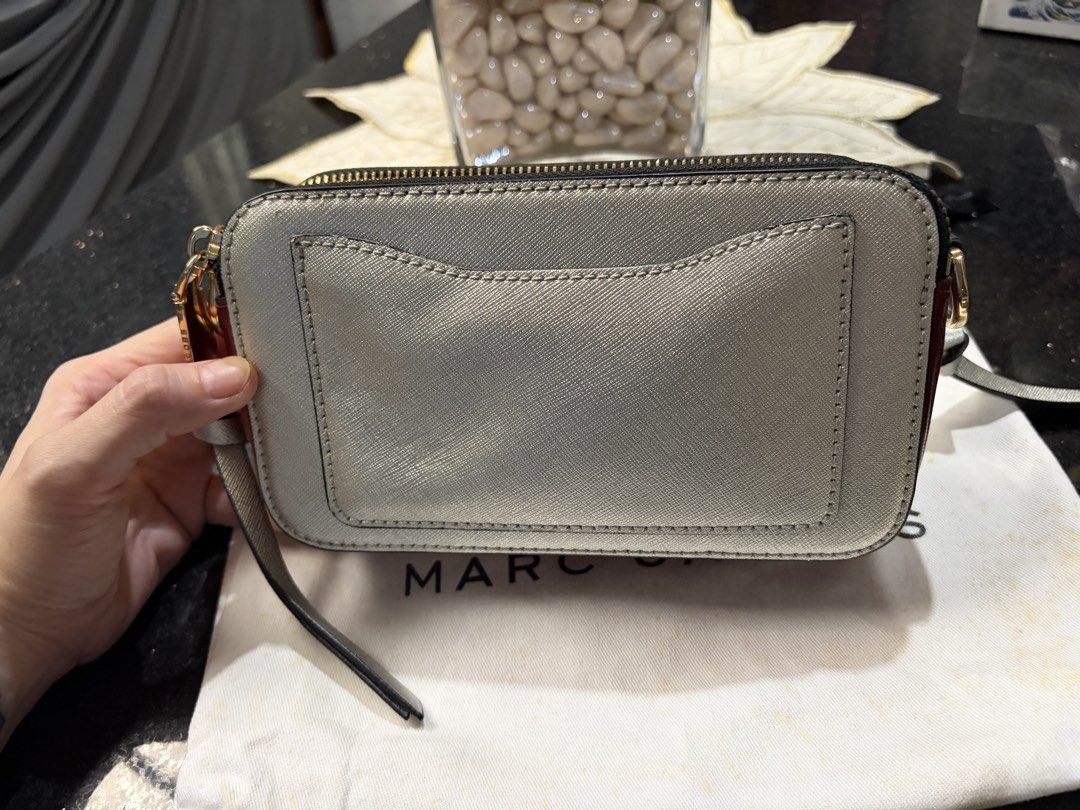 Marc Jacobs Snapshot Camera Bag Silver Burgundy (Category: Luxury Bags & Wallets) located in Cebu City. Submitted by broodie (Listing ID 1462110821, Image 3). Description: - Authentic Marc Jacobs Snapshot camera bag - Chic silver and burgundy Saffiano leather - Features signature gold tone hardware and secure zipper closure - Convenient back pocket for quick access - Comes with the iconic striped strap - Includes original dust bag for protection 