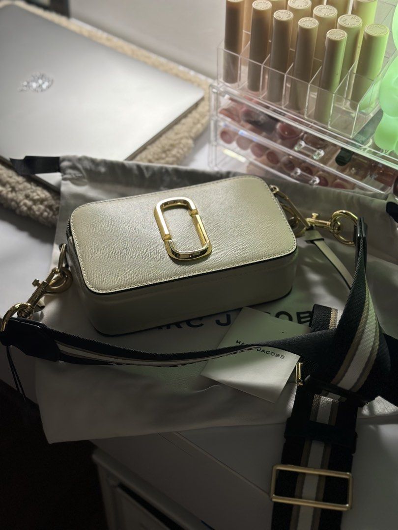 Marc Jacobs Snapshot Camera Bag Cream Gold (Category: Luxury Bags & Wallets) located in Manila. Submitted by tinne15 (Listing ID 1462157868, Image 2). Description: - Authentic Marc Jacobs Snapshot camera bag - Color: Cream and Black - Hardware: Gold - Includes original dust bag - Includes authenticity card - Strap features 'The Snapshot Marc Jacobs' print - Versatile for everyday use or evening events.