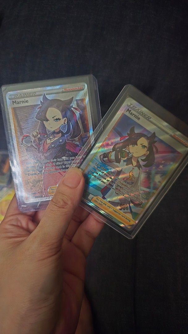 Marnie Trainer Supporter Pokemon Card (Category: Raw Singles) located in Cavite. Submitted by vttorres (Listing ID 1462064893, Image 1). Description: - Two (2) Marnie Trainer Supporter Pokemon cards - Both cards are in protective sleeves - Rare addition for any Pokemon TCG collector - Grab these sought-after cards today!.