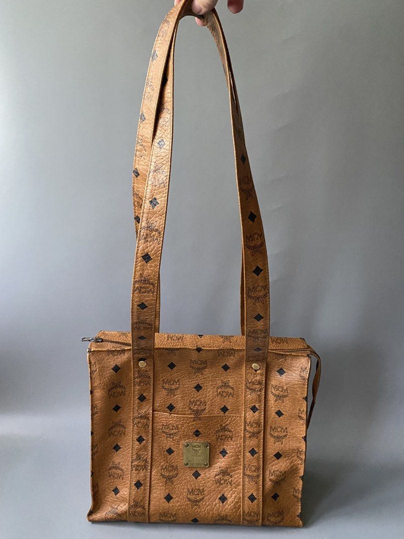 MCM Monogram Tote Bag (Category: Luxury Bags & Wallets) located in Tagbilaran City. Submitted by cay1509 (Listing ID 1462108945, Image 1). Description: - Original Japan bought Classic MCM tote bag - All-over monogram print - Tan leather with black MCM logos - Zipper closure at the top - Interior zippered pocket - Metal logo plate on the front - Comfortable shoulder straps.