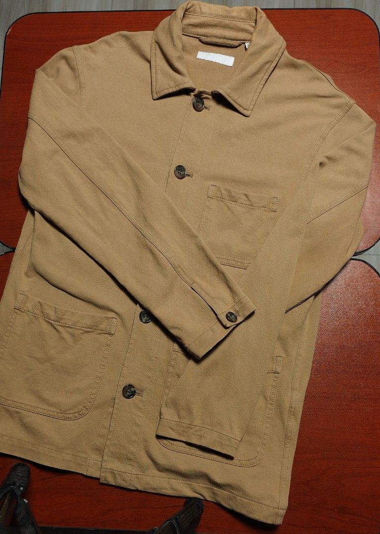 Men's / Unisex Tan Workwear Chore Jacket (Category: Coats, Jackets and Outerwear) located in Santa Rosa. Submitted by ethan_ld (Listing ID 1462214584, Image 1). Description: Selling this authentic UNIQLO Men's Washed Utility Jacket in a versatile tan/brown colorway. It is built with a rugged, classic workwear aesthetic but crafted from a soft, stretchable jersey lining that feels as cozy as a sweatshirt. Super easy to style as a casual overshirt 