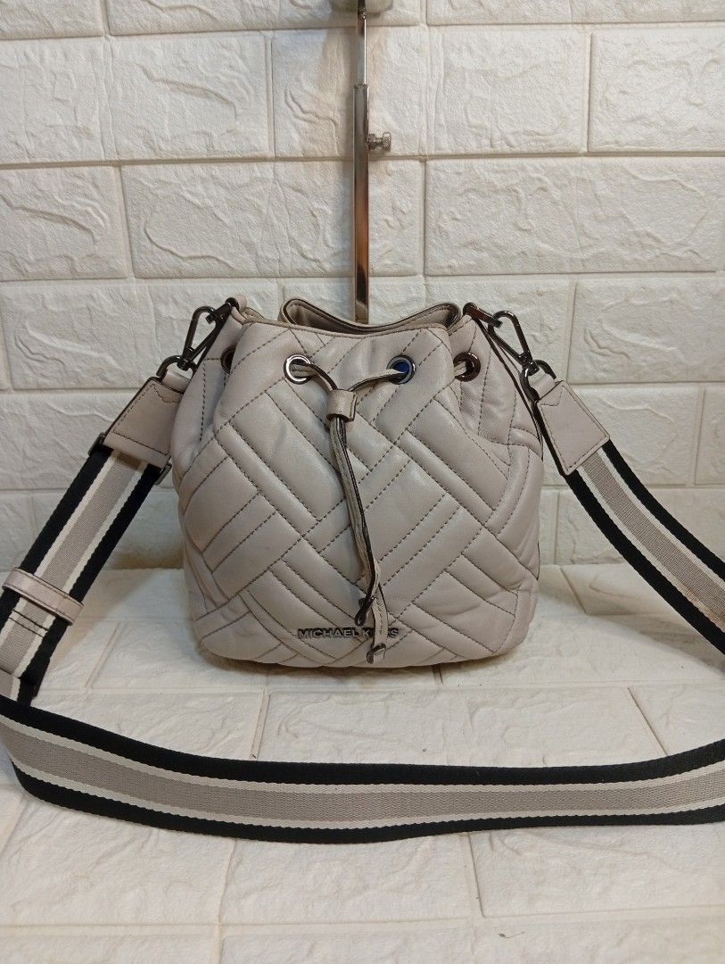 Michael Kors Quilted Leather Bucket Bag (Category: Cross-body Bags) located in Las Pinas. Submitted by etoksi1234 (Listing ID 1462184616, Image 1). Description: Pre-loved Michael Kors Extra Small Peyton Quilted Bucket Crossbody Bag, featured in a soft cement-grey leather with a sporty striped webbing strap..
