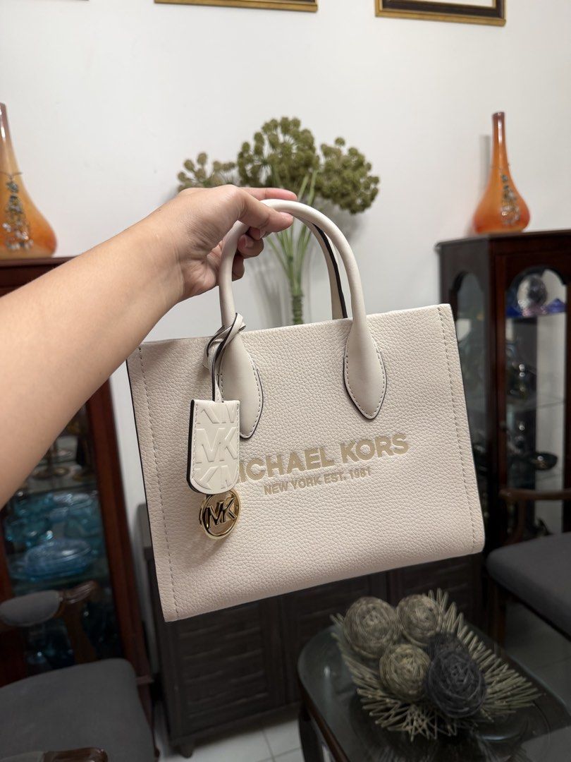 Michael Kors 2 way Bag - White (Category: Tote Bags) located in Cavite. Submitted by denimloveph2020 (Listing ID 1462134378, Image 1). Description: - Authentic Michael Kors tote bag in crisp white. - Crafted from premium textured leather. - Elegant gold-tone hardware. - Features iconic Michael Kors logo and 'New York Est. 1981' embellishment. - Comes with a stylish detachable MK charm. - Comfortable top handles for easy carrying. - Ideal as a chi