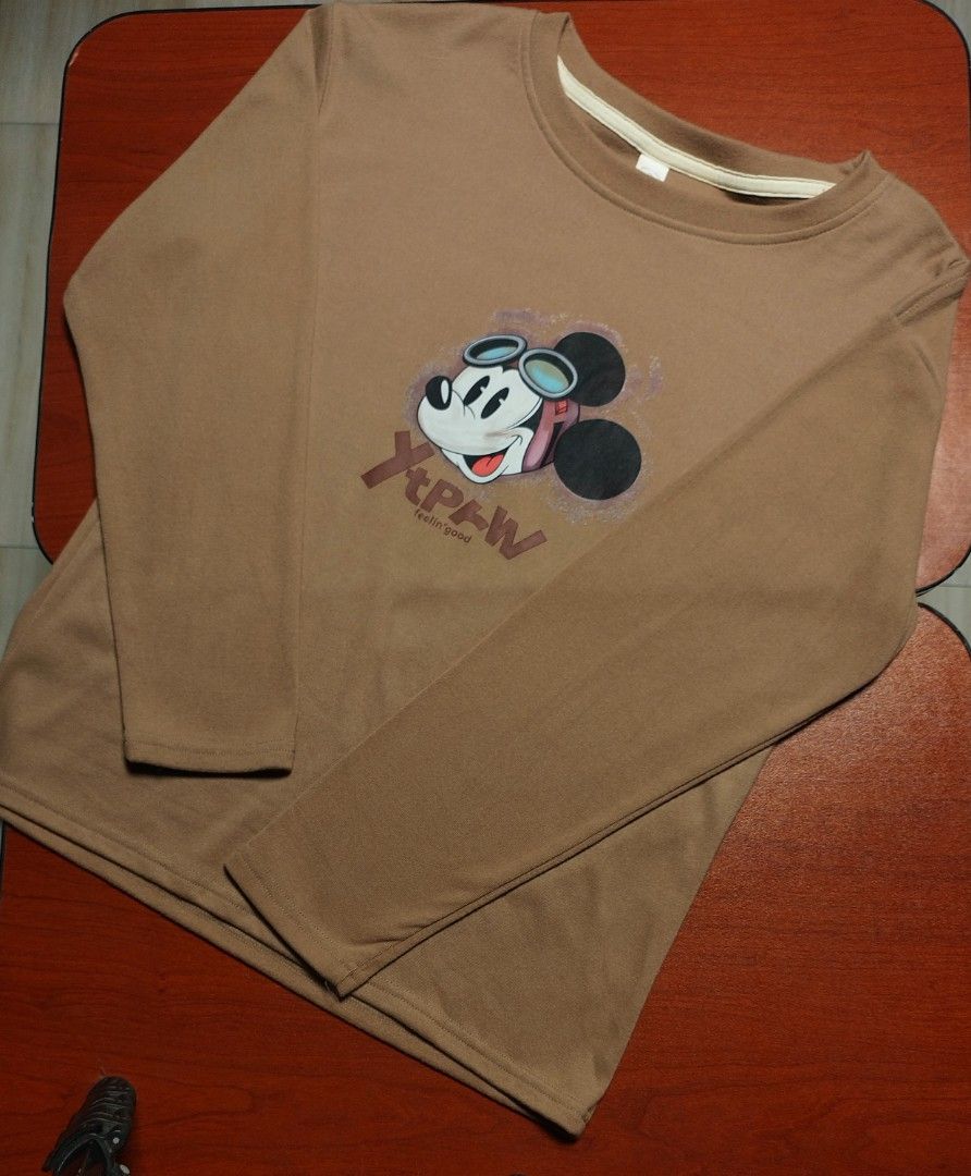 Mickey Mouse Aviator Long Sleeve Top (Tan/Brown) (Category: Coats, Jackets and Outerwear) located in Santa Rosa. Submitted by ethan_ld (Listing ID 1462211052, Image 1). Description: Selling this comfortable and stylish Mickey Mouse long-sleeve tee! Features a cool graphic of Mickey wearing aviator goggles and headphones with "Feelin' good" text. Great for casual everyday wear, study sessions, or styling a relaxed look for mall trips..