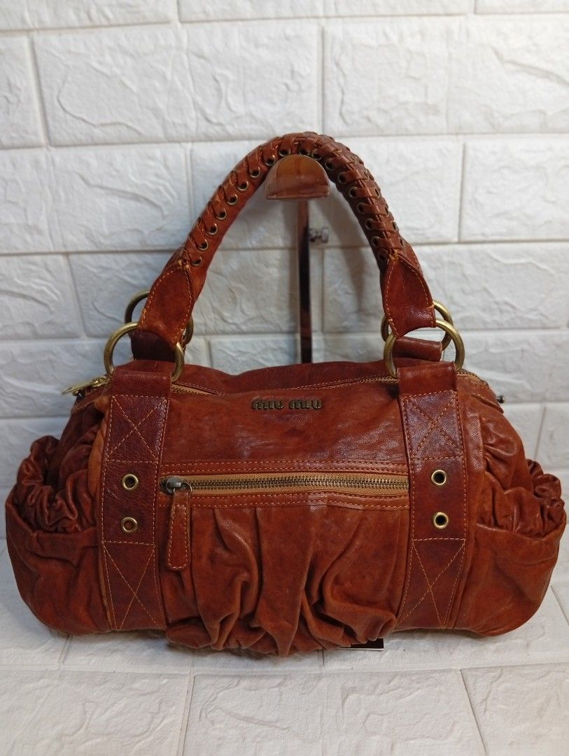 Miu Miu Brown Leather Gathered Shoulder Bag (Category: Shoulder Bags) located in Las Pinas. Submitted by etoksi1234 (Listing ID 1462123045, Image 1). Description: Pre-loved Miu Miu vintage brown leather satchel featuring a braided top handle and gathered front pocket detailing. NO WHTE TAG AND UNDERZIP.