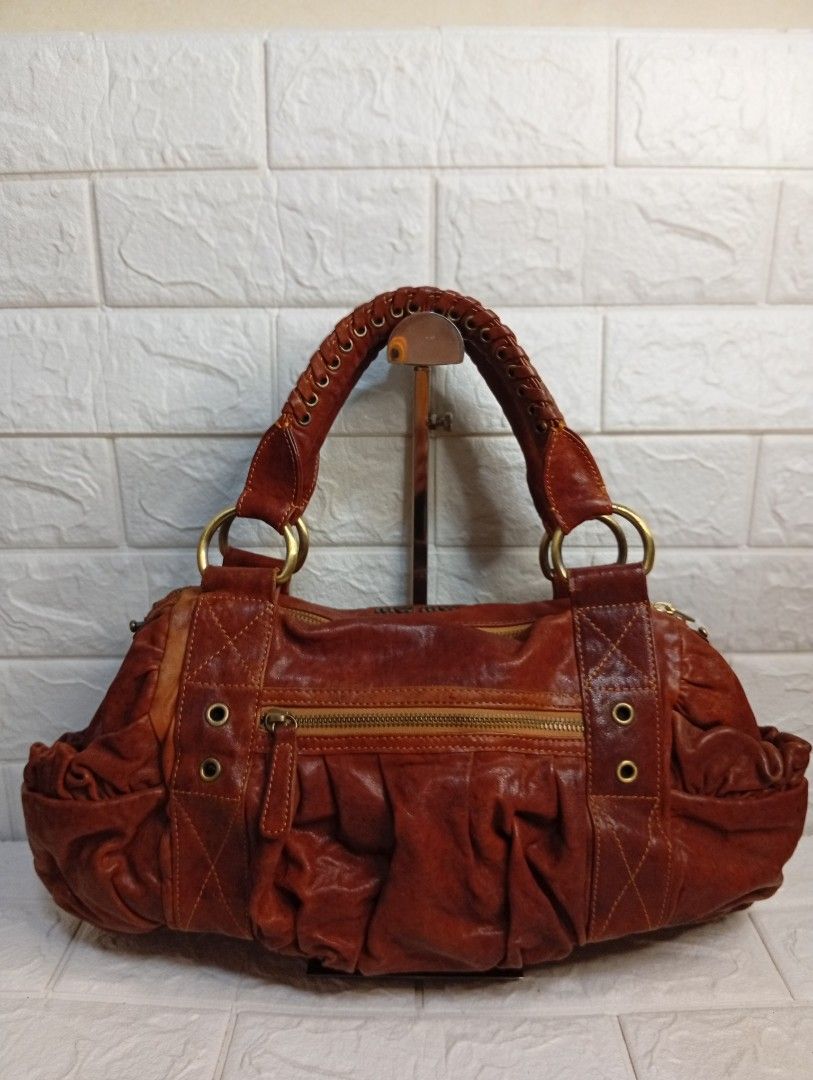 Miu Miu Brown Leather Gathered Shoulder Bag (Category: Shoulder Bags) located in Las Pinas. Submitted by etoksi1234 (Listing ID 1462123045, Image 2). Description: Pre-loved Miu Miu vintage brown leather satchel featuring a braided top handle and gathered front pocket detailing. NO WHTE TAG AND UNDERZIP.