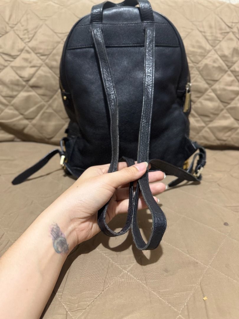 MK RHEA (MEDIUM SIZE) (Category: Backpacks) located in San Pablo. Submitted by calmhawk.60c993 (Listing ID 1462091902, Image 3). Description: The item appears to be a black pebbled leather Michael Kors Rhea Medium Studded Backpack featuring striking gold pyramid studs along the front pocket. Slightly used kasya po macbook neo since med size po siya... kulang lang po ng dalawang studd sa gilid pls see the last pics...